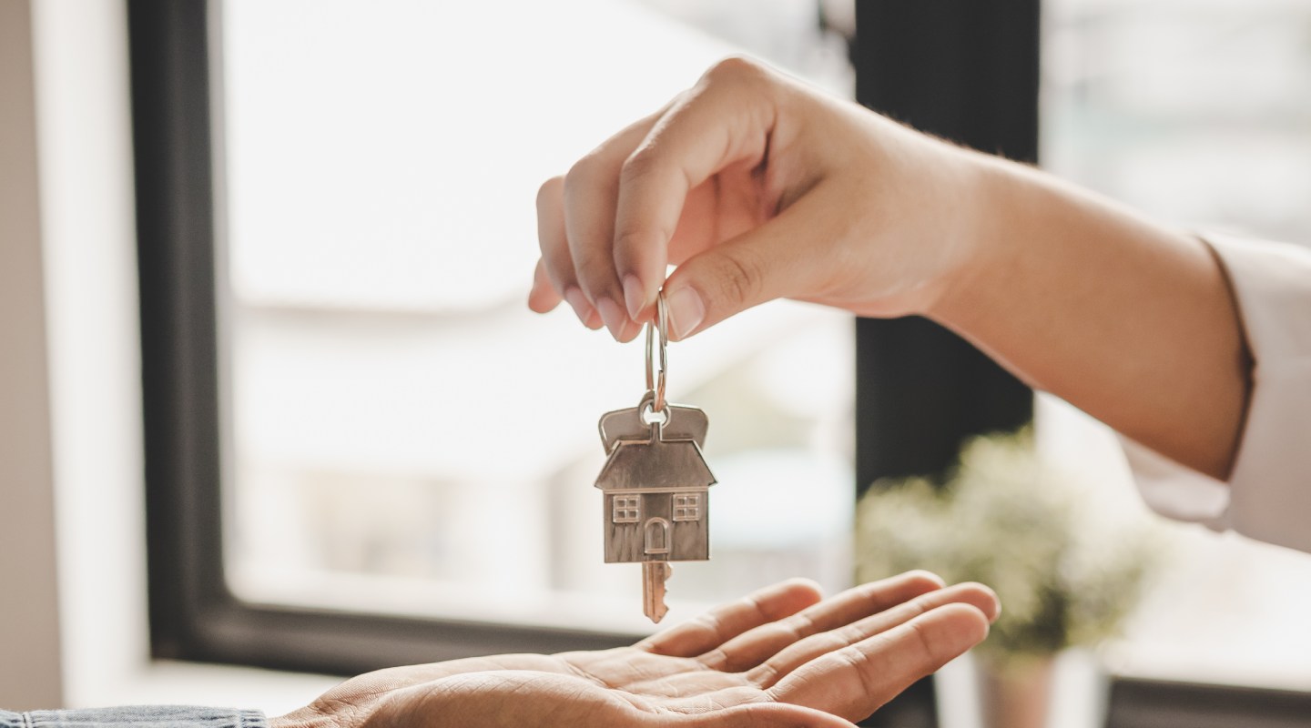 Échange de clés de maison entre deux mains, symbolisant la remise d’un bien immobilier